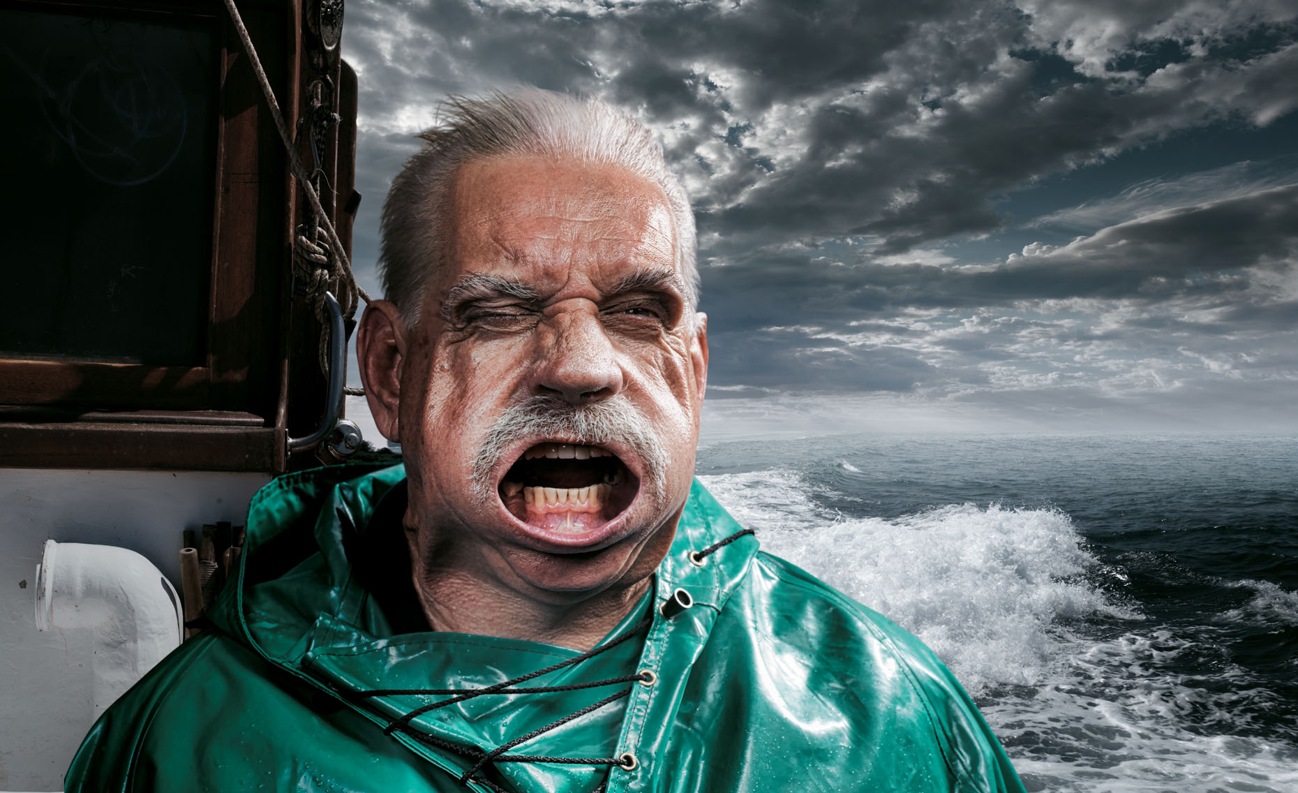 Portrait of an aged fisherman on his boat in a stormy sea. 