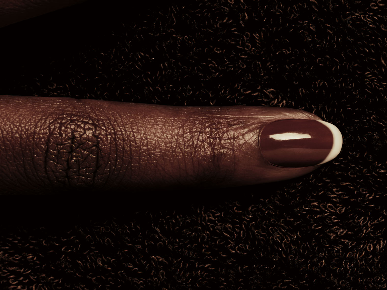 Black female finger with a French manicure.