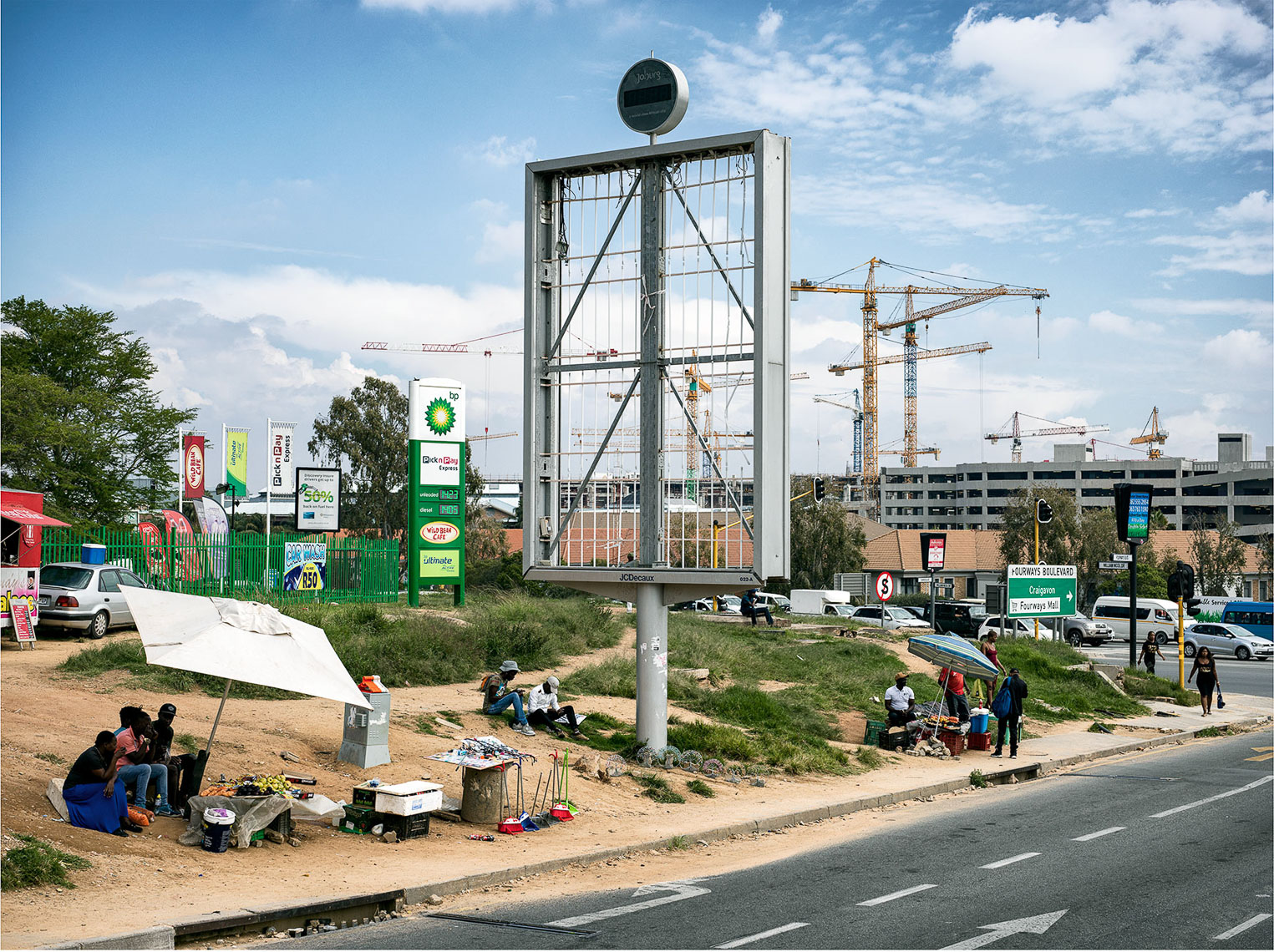 Empty billboard in an urban landscape with people and hawkers going about their daily lives. 