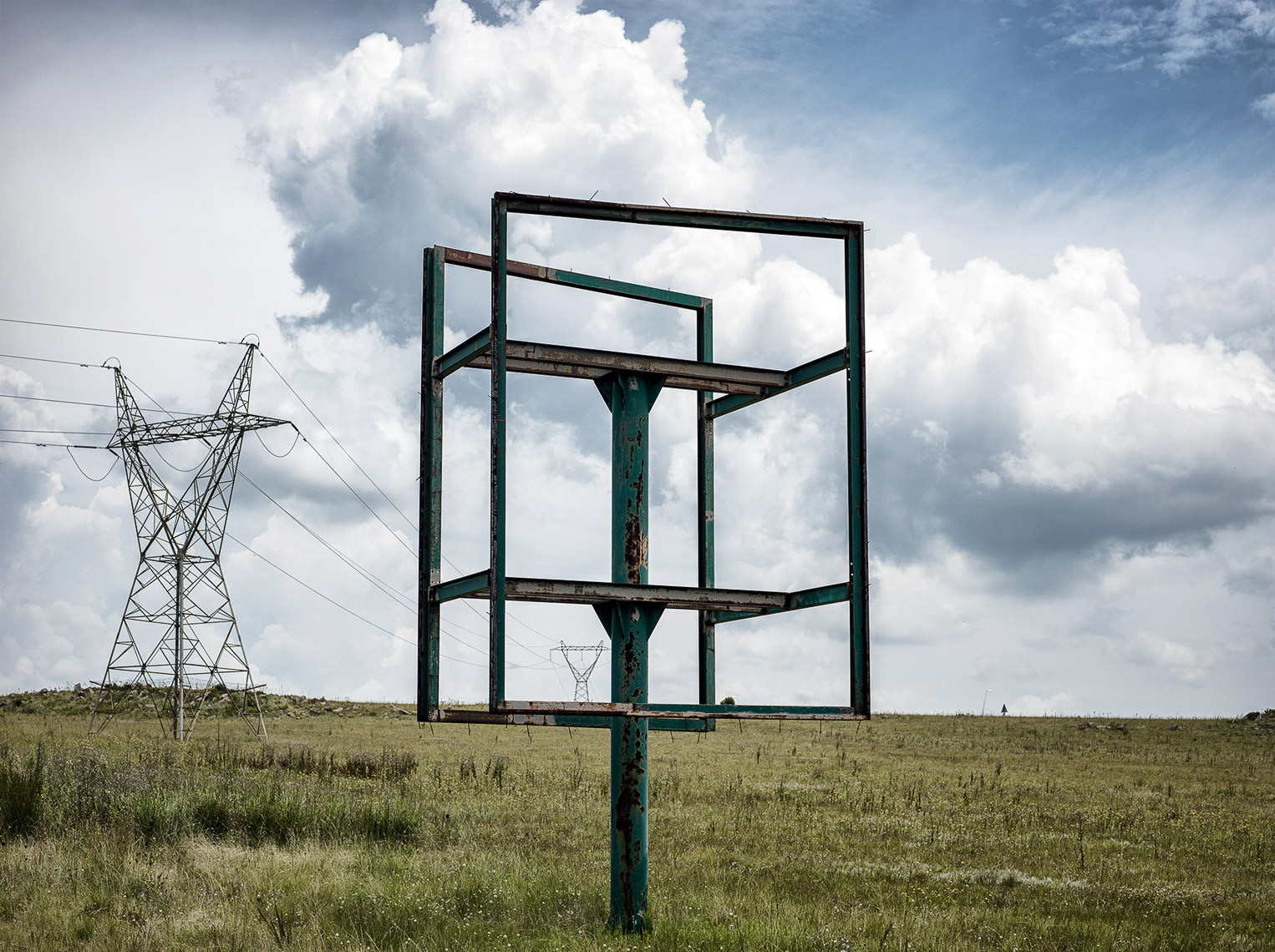 Empty billboard in landscape with electrical pylons in the background. 