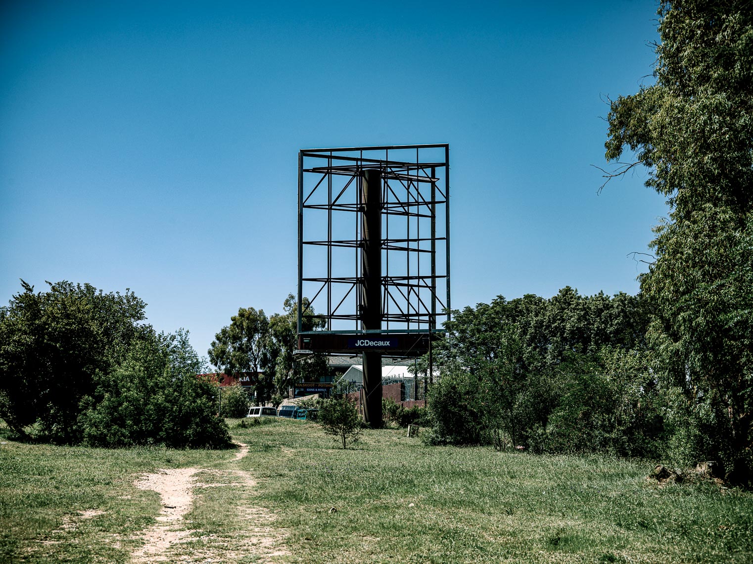 Empty billboard next to a dusty road.
