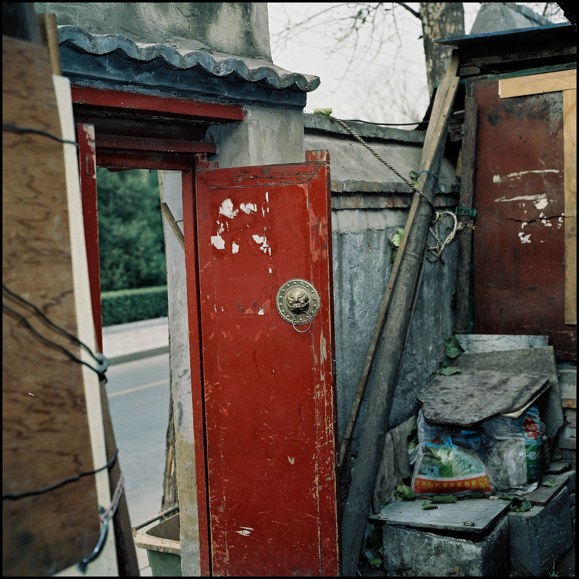 A door opening out from the narrow alleys to the streets of Beijing and the world outside. 