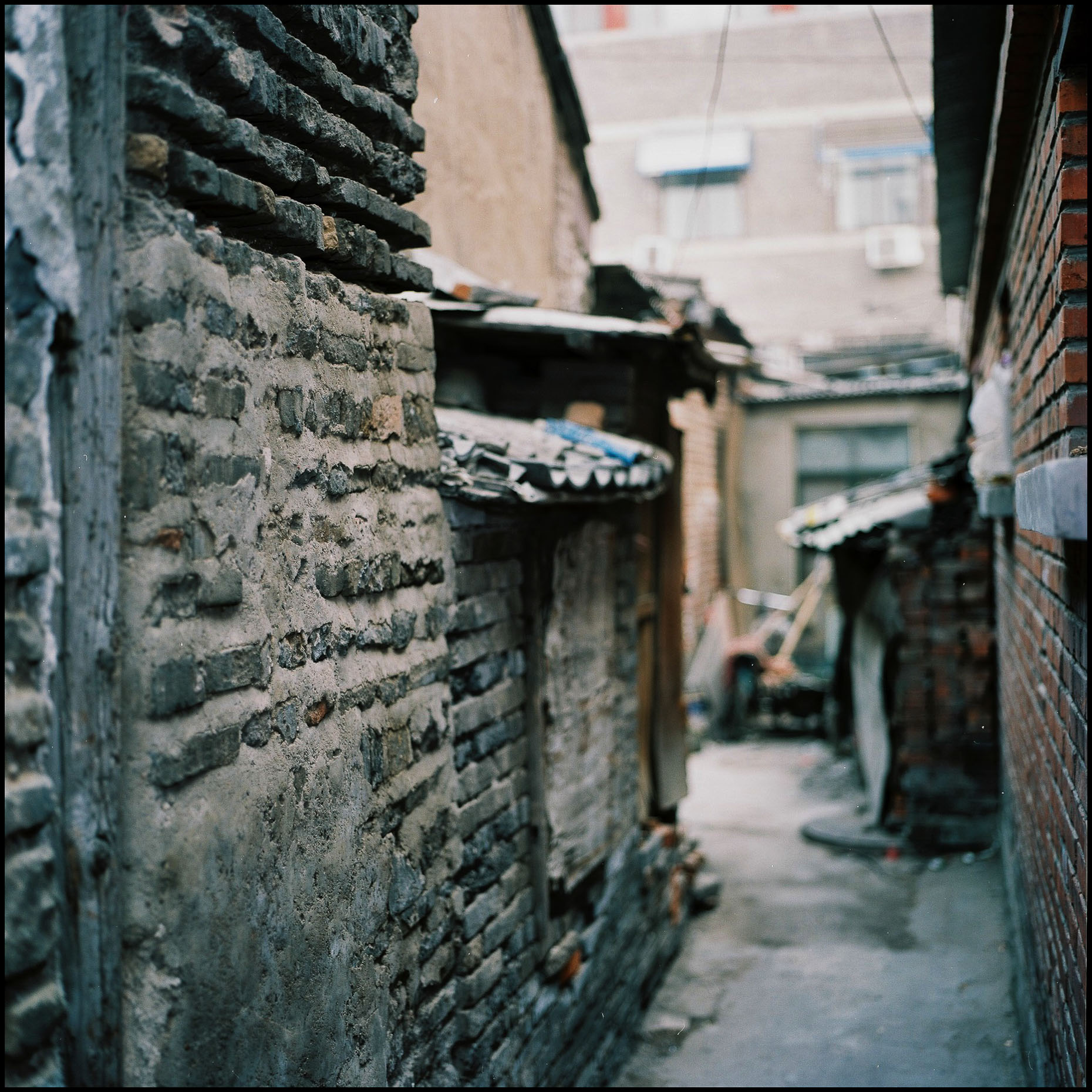 Grey brick structures built on a Hutong.
