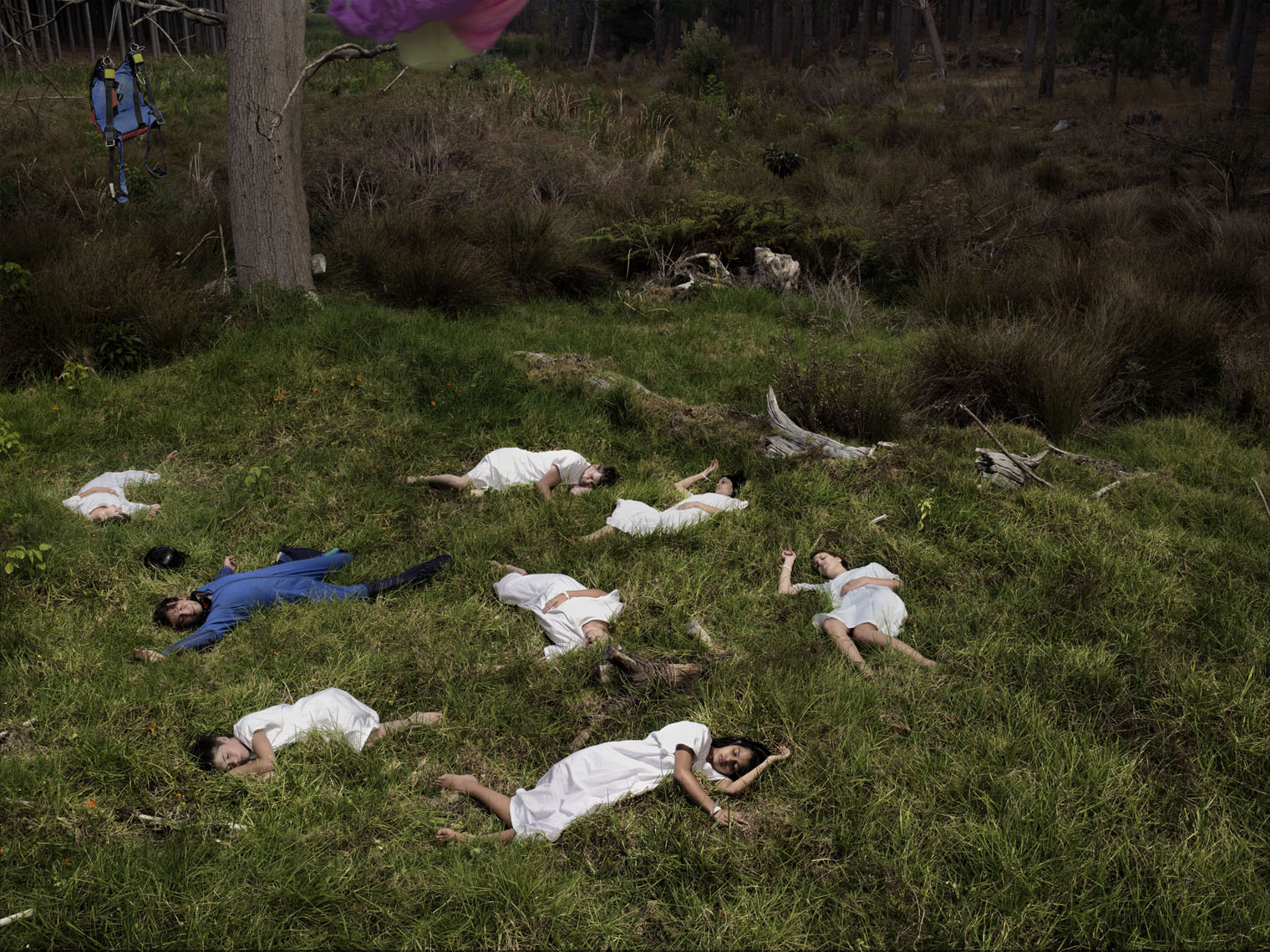 7 people lying on the forest floor representing death because of one person not donating their organs. 