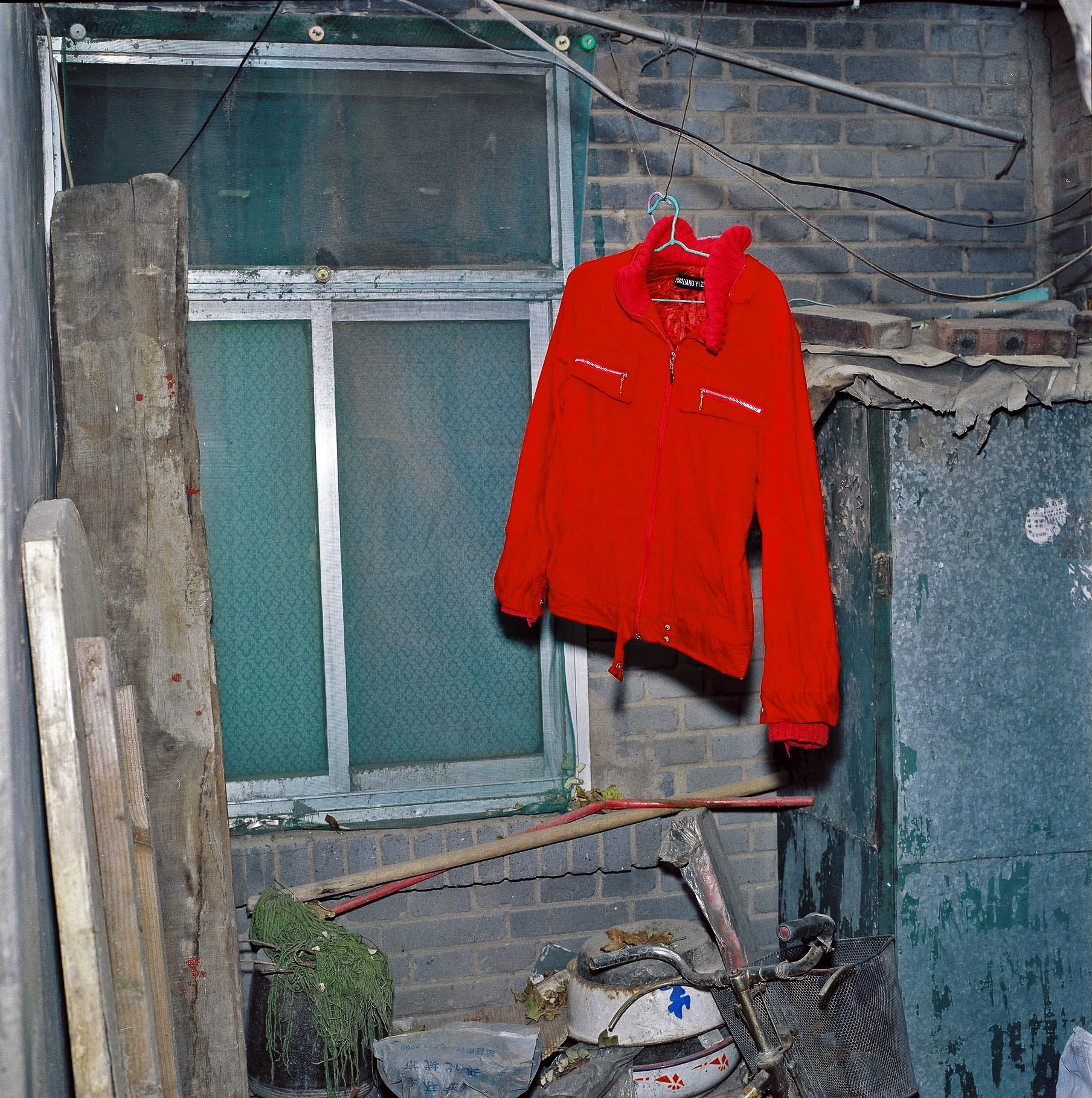 Red sweater drying outside a window. 