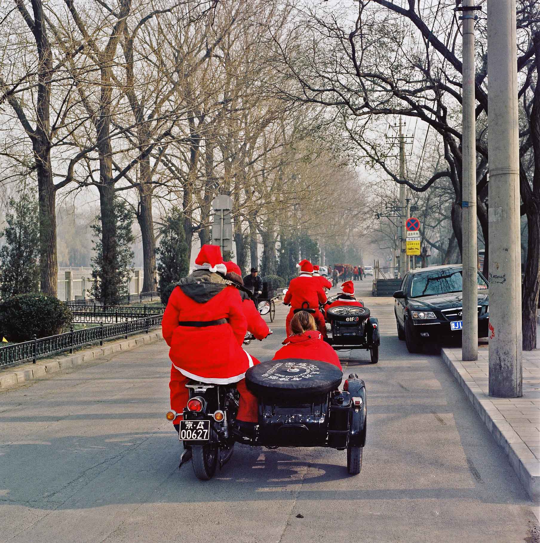 Two men dressed as Father Christmas, cruising the streets on a motorbike and sidecar. 