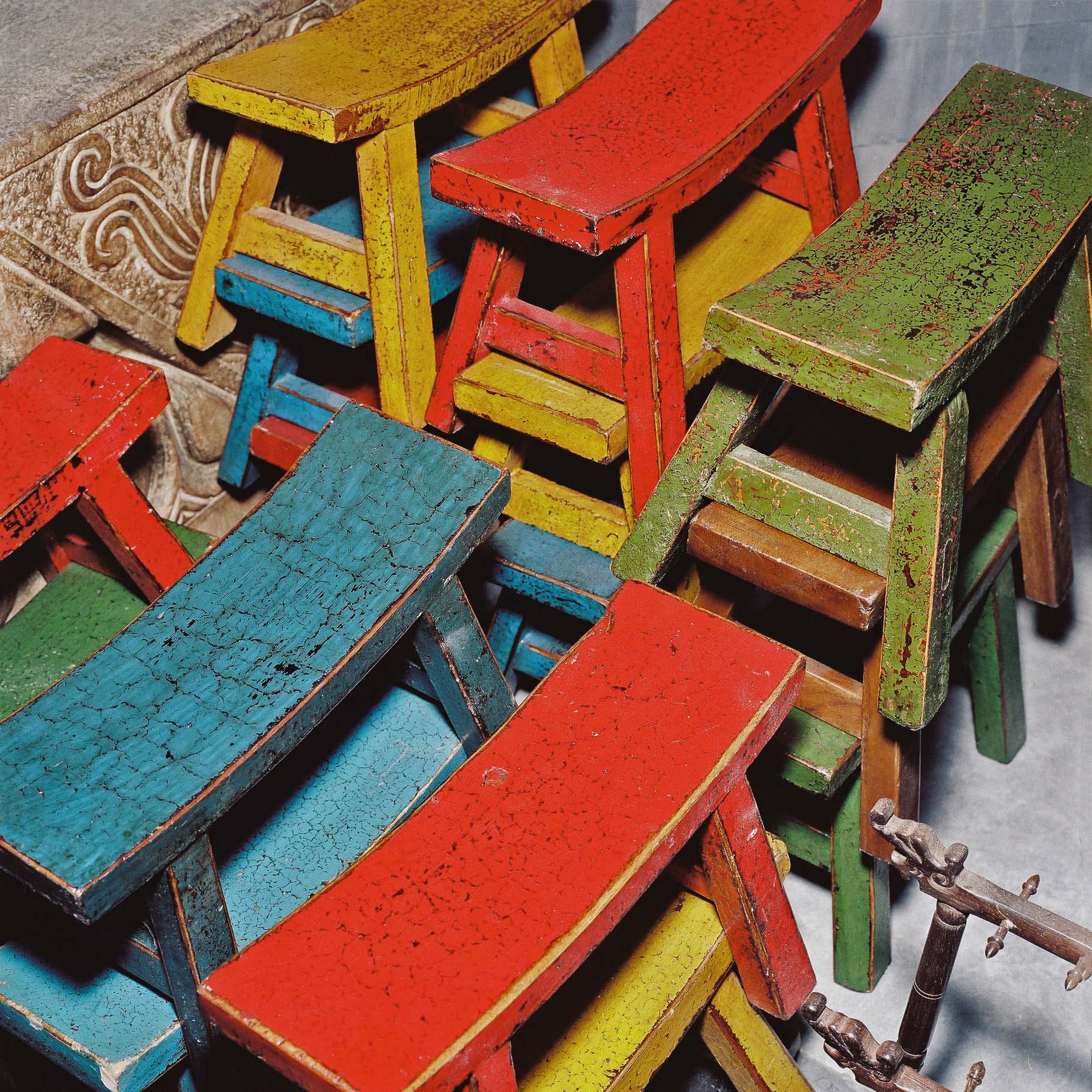A collection of chinese stools in various colours. 