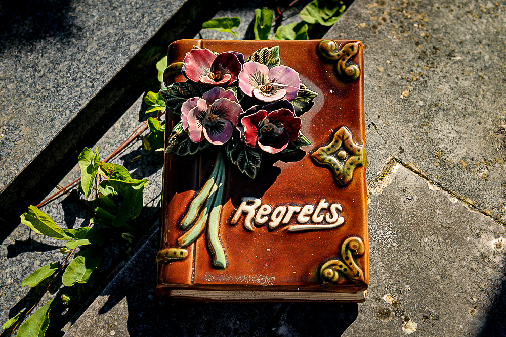 A beautiful hand made majolica grave decoration in the shape of a book, titled, Regrets. 