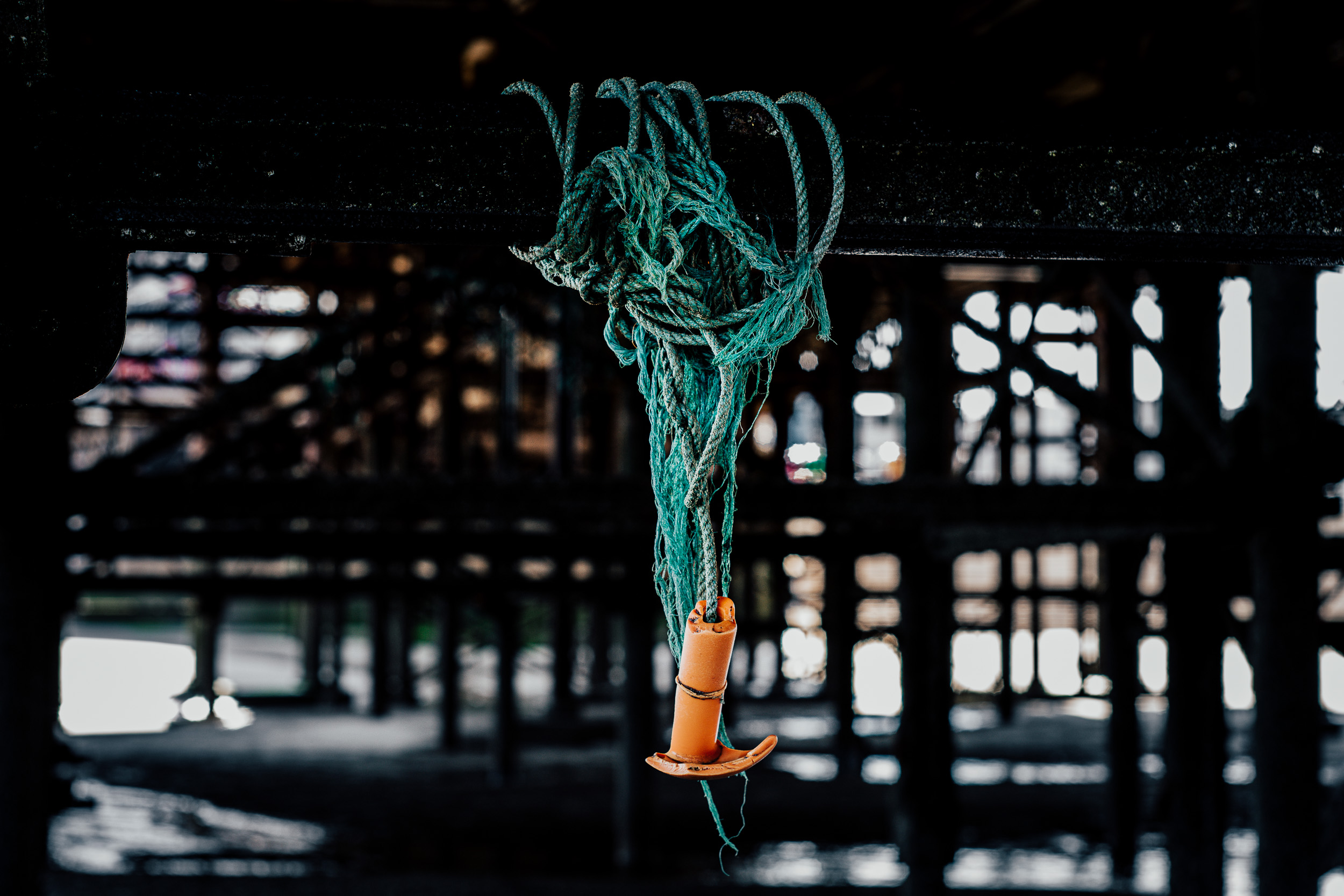 Green rope with orange, plastic, broken grip hanging off the steel  structure of the Blackpool pier. 